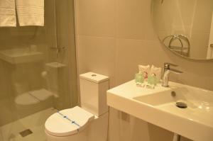 a bathroom with a toilet and a sink and a mirror at Hotel Airiños 3* in Cangas de Morrazo