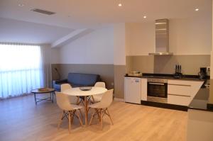 a kitchen and living room with a table and chairs at Hotel Airiños 3* in Cangas de Morrazo