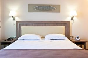 a bedroom with a large bed with two pillows at Villa Azur in Villeneuve-Loubet