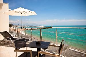 a patio with a table and chairs and the ocean at Villa Azur in Villeneuve-Loubet