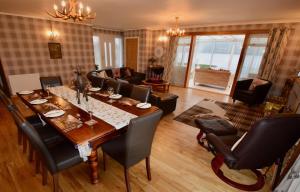 a dining room with a table and a living room at Jenny's Bay at Loch Goil in Lochgoilhead