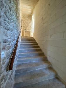 eine Treppe in einem Gebäude mit einer Steinmauer in der Unterkunft Château de la Garnison in Orvault