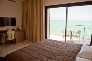 a hotel room with a bed and a view of the ocean at Villa Azur in Villeneuve-Loubet