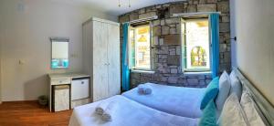 a bedroom with a bed and a stone wall at Oberj d'Azur Alaçatı in Alaçatı