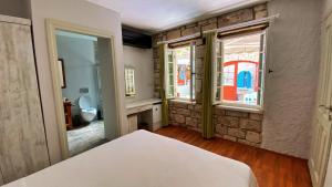 a bedroom with a bed and a stone wall at Oberj d'Azur Alaçatı in Alaçatı