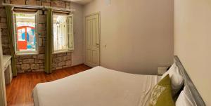 a bedroom with a bed and two windows at Oberj d'Azur Alaçatı in Alaçatı