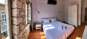 a bedroom with a bed and a brick wall at Oberj d'Azur Alaçatı in Alaçatı