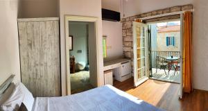 a bedroom with a bed and a balcony with a table at Oberj d'Azur Alaçatı in Alaçatı