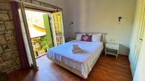 a bedroom with a bed and a large window at Oberj d'Azur Alaçatı in Alaçatı