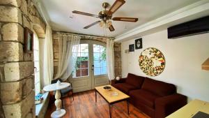 a living room with a couch and a ceiling fan at Oberj d'Azur Alaçatı in Alaçatı