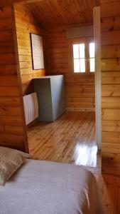 1 dormitorio con 1 cama en una cabaña de madera en Casa Azul en Santillana del Mar