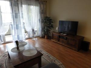 a living room with a flat screen tv and a table at Apartement Basti in Pobierowo