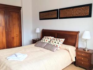 ein Schlafzimmer mit einem Bett mit einem Kopfteil aus Holz in der Unterkunft Apartment Ronda City Center in Ronda