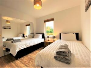a bedroom with two beds and a window at Grampian Serviced Apartments - Garden Neuk - Lesmurdie House in Elgin