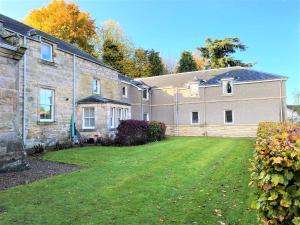 une grande maison en briques avec une cour devant elle dans l'établissement Grampian Serviced Apartments - Garden Neuk - Lesmurdie House, à Elgin