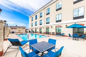 FloresvilleにあるHoliday Inn Express Hotel & Suites Floresville by IHGのパティオ(テーブル、椅子付)、プールが備わります。