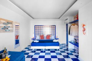 - une chambre avec un lit bleu et un sol en damier dans l'établissement Maison Serena Sorrento, à Sorrente