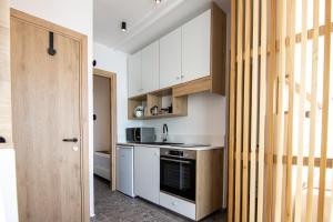 uma cozinha com armários brancos e um forno com placa de fogão em Phaedrus Living Seaview Modern Flat Lighthouse 52 em Paphos