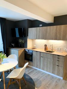 a kitchen with wooden cabinets and a table and chairs at Suite Living Boardinghouse Apartments in Gießen