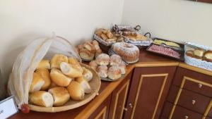 a counter with many different types of bread on it at Pousada FM - Vila Capivari in Campos do Jordão