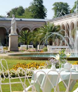 einen Tisch und Stühle vor einem Brunnen in der Unterkunft Villa Thea Hotel am Rosengarten in Bad Kissingen