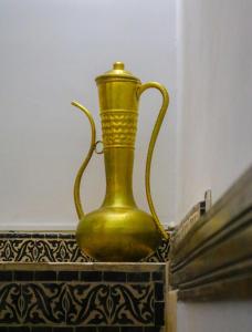 un vaso d'oro seduto sopra un tavolo di Dar Habache a Marrakech