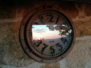 a clock with a reflection of the sunset in it at Casa da Costinha in Cinfães
