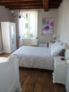 Een bed of bedden in een kamer bij A L'Ombre Du Marronnier GITES