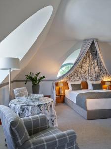 sypialnia z łóżkiem, stołem i kanapą w obiekcie Schloss Hotel Dresden Pillnitz w Dreźnie