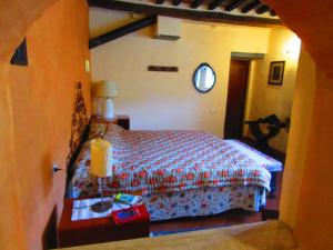 1 dormitorio con 1 cama y 1 mesa con lámpara en Il Mandorlo di Monteriggioni en Monteriggioni