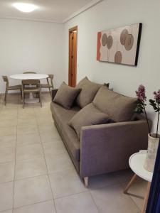 ein Wohnzimmer mit einem Sofa und einem Tisch in der Unterkunft Torrevieja 2 in Torrevieja