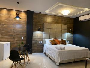 1 dormitorio con 1 cama grande, mesa y sillas en Hotel Sandis en Santarém