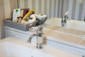 a bathroom sink with a soap dispenser next to it at Schloss Hotel Dresden Pillnitz in Dresden