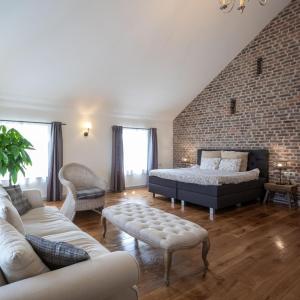 1 dormitorio con cama y pared de ladrillo en B&B De Bloesem, en Hoeselt