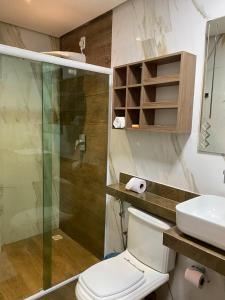 La salle de bains est pourvue de toilettes et d'une douche en verre. dans l'établissement Hotel Sandis, à Santarém