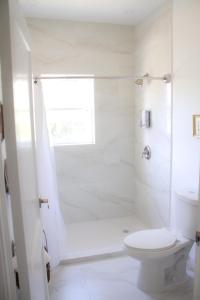 a white bathroom with a toilet and a shower at Spacious and Comfy Suite near MIA - 6G in Miami