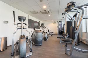 a gym with several treadmills and exercise bikes at WestCord Fashion Hotel Amsterdam in Amsterdam