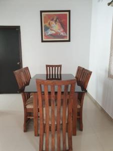 een eettafel met 4 stoelen en een schilderij bij MoonLight By Leela Homes in Arpora