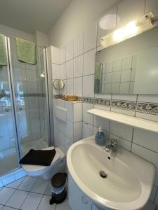 a bathroom with a sink and a shower and a toilet at Ferienwohnungen Glückstadt in Glückstadt