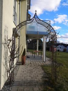 an archway outside of a building with a bench at LandLebenLeuter in Glochen