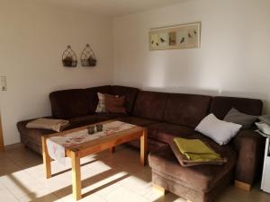 sala de estar con sofá marrón y mesa en LandLebenLeuter, en Glochen