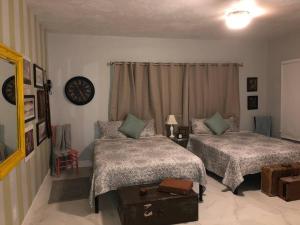 um quarto com duas camas e um relógio na parede em Spacious and Comfy Suite near MIA - 6G em Miami