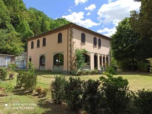 a large building with trees in the background at Villa La Ginestra - Charming Country Home in Capolona