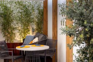 une table et des chaises sur une terrasse agrémentée de plantes dans l'établissement STUPENDO- Two Rooms, patio With refreshing Pond-Center-Air conditioning-Free Park, à Lisbonne