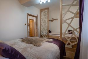 a furry animal laying on a bed in a room at GOLDENapartment in Veľká Lomnica