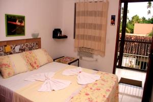 a bedroom with a bed with two towels on it at Camping e Chalés Beira Mar in Maragogi