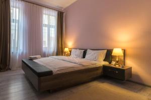a bedroom with a bed with two lamps on it at Apartment Queen in Sibiu