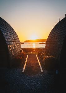 a sunset over a road between two buildings at Ocean Village Resort in Tofino