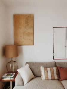 een woonkamer met een bank en een kaart aan de muur bij Maria Tereza Sea Villa in Costa da Caparica