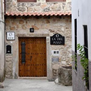 un edificio con una puerta de madera con un cartel en La del Pozo, en Montánchez